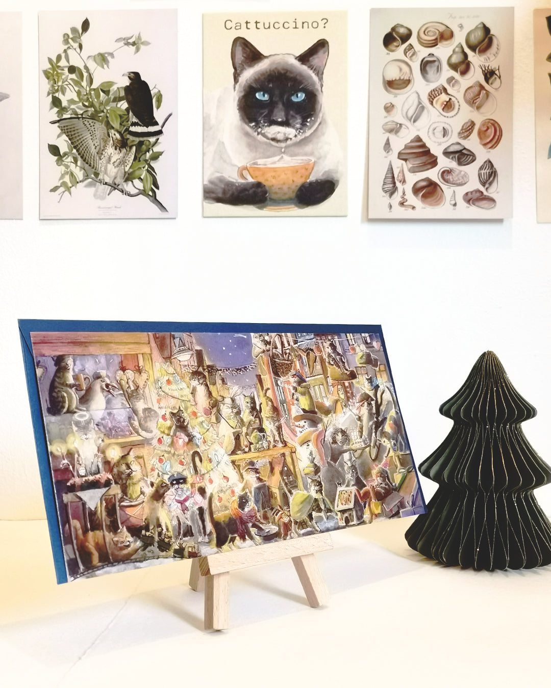 Weihnachtskarte mit ganz vielen Katzen. Es sind die Streetart Katzen aus der Norderstraße Flensburg als Aquarell Illustration und warmen Farben gestaltet. Jede Katze macht etwas anderes weihnachtliches. Kekse backen, Lebkuchenhaus bauen, Sternschnuppen sieht man, Ein Katze mit Schneeball, eine Punschbude. Individuelle Karten und ein gutes Geschenk.