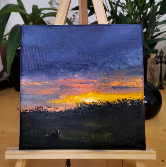 Ölmalerei Landschaft auf kleiner Leinwand 10x10 cm. Das Bild zeigt einen Sonnenuntergang mit einem harmonischen Farbspektrum. Im Vordergrund eine Wiese mit einer Katze. 